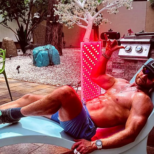 A fit man using his Vital Elite red light therapy device for muscle recovery and biohacking